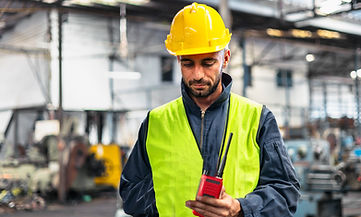 Manufacturing Employee using a walkie talkie or radio to communicate