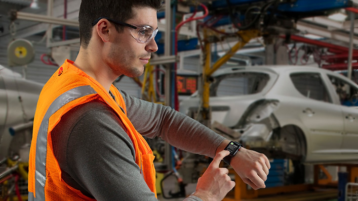 Man receiving a SQUEAKS alert in a manufacturing plant, showing SQUEAKS driving action.
